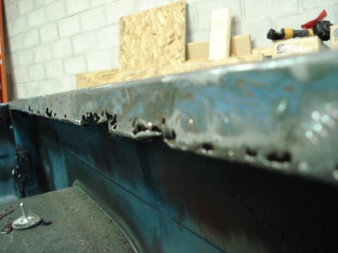 1979 Chevrolet C/K Pickup - The top edge of a truck bed shows significant rust damage and holes.