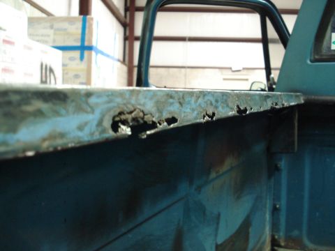 1979 Chevrolet C/K Pickup - Detail of corrosion on the upper edge of a truck bed, showing significant rust damage.