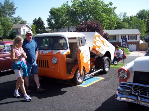 1972 Ford Ranchero - A custom orange and white pickup truck with flame decals is parked at an outdoor event.