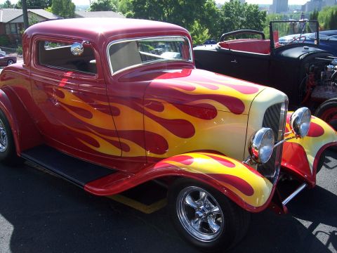 1972 Ford Ranchero - A classic hot rod coupe with a vibrant flame paint job sits parked outdoors.