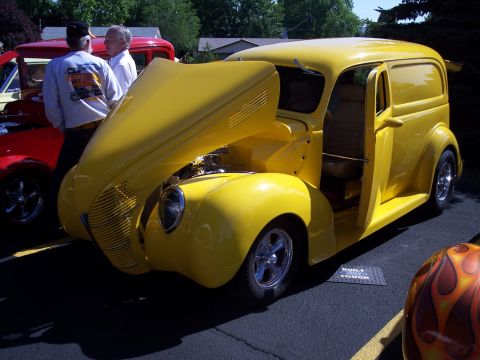 1972 Ford Ranchero - A bright yellow panel van is displayed with its hood and driver's door open, revealing the engine and interior.