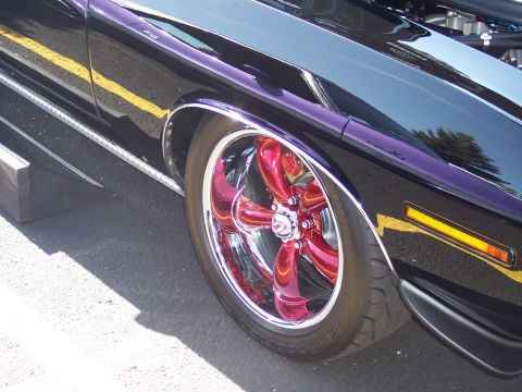 1972 Ford Ranchero - A custom wheel with red spokes and a chrome lip is shown on a dark-colored vehicle.