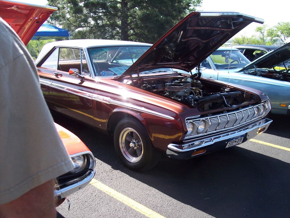 Red 1970s pickup truck, hood open, parked outdoors with other vehicles