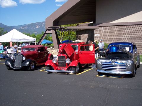 1972 Ford Ranchero - A collection of vehicles are parked outdoors under a covered area, with mountains visible in the background.