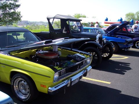 1972 Ford Ranchero - A yellow car with its hood open is parked alongside other vehicles at an outdoor event.