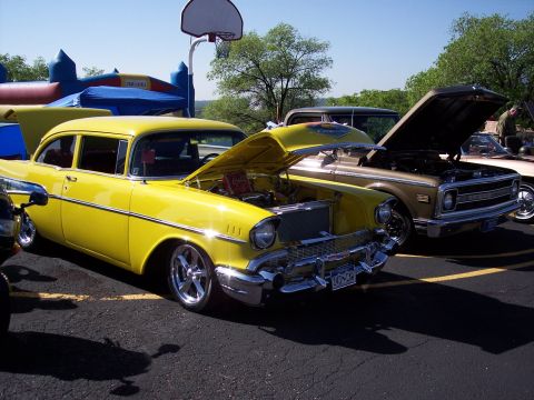 1972 Ford Ranchero - Two classic vehicles, a yellow sedan and a brown pickup, are displayed at an outdoor event.
