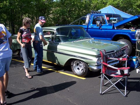 1972 Ford Ranchero - A light green 1959 Chevrolet El Camino is displayed at an outdoor event with a blue pickup truck in the background.