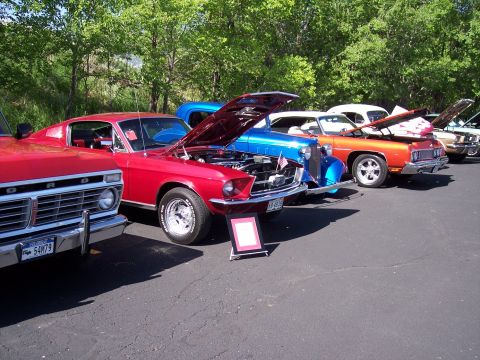 1972 Ford Ranchero - Several classic cars are lined up with their hoods open, displaying their engines at an outdoor event.
