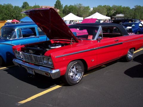 1972 Ford Ranchero - A red 1965 Ford Falcon Futura coupe is displayed with its hood open at an outdoor event.