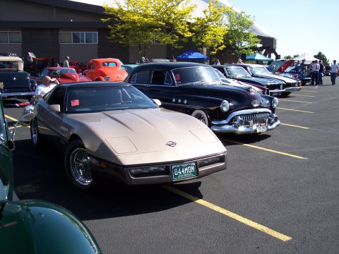 1972 Ford Ranchero - A tan 1984 Chevrolet Corvette C4 is parked at a car show next to other classic vehicles.