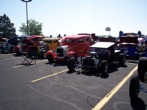 1972 Ford Ranchero - A collection of custom hot rod vehicles are displayed in an outdoor parking lot.