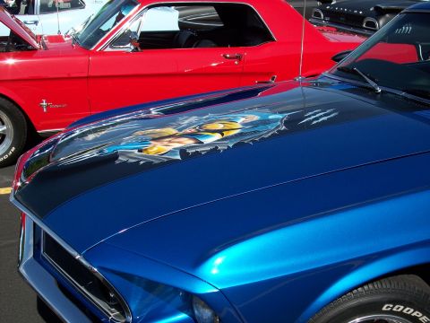 1972 Ford Ranchero - Two classic American muscle cars are parked side-by-side, one custom airbrush art on its hood.