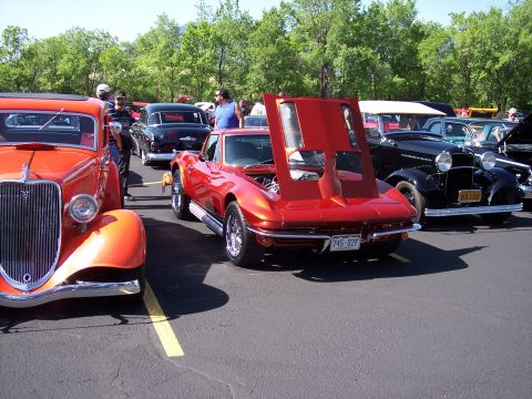 1972 Ford Ranchero - A red 1965 Corvette Sting Ray is displayed with its hood up at a car show, alongside other vintage vehicles.