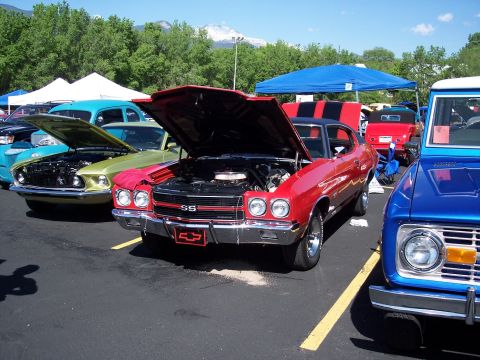 1972 Ford Ranchero - A red Chevrolet Chevelle SS is displayed with its hood up at a car show, alongside other classic vehicles.