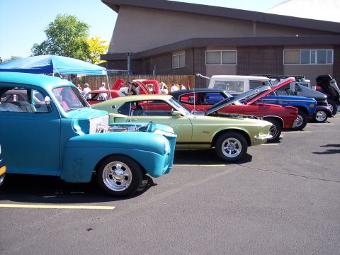 1972 Ford Ranchero - A row of vintage vehicles are parked at an outdoor event on a sunny day.