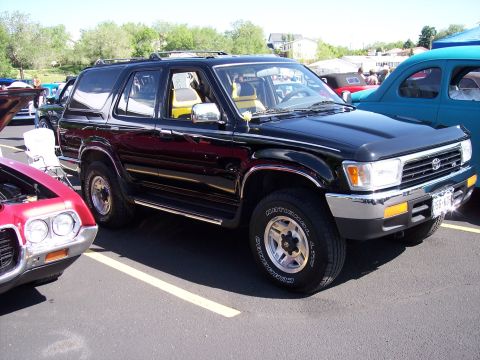 1972 Ford Ranchero - A black SUV is parked in a lot, with other vehicles visible around it.