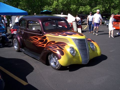 1972 Ford Ranchero - A customized 1937 Ford Sedan hot rod with flame graphics is displayed at an outdoor event.