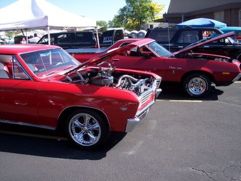 1972 Ford Ranchero - A red 1970 Ford Ranchero 500 is parked with its hood open, alongside another red vehicle.