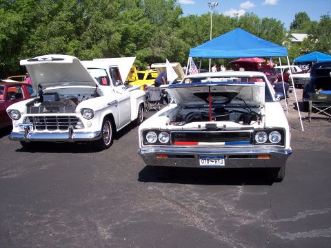 1972 Ford Ranchero - Two classic American cars, a Ford Ranchero and a Chevrolet pickup, displayed with their engines visible at an outdoor event.