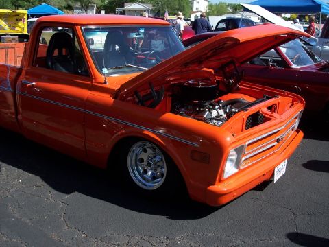 1972 Ford Ranchero - This orange 1971 Chevrolet C10 pickup truck is displayed with its hood open, revealing the engine bay.