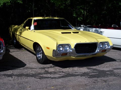 1972 Ford Ranchero - Yellow 1972 Ford Ranchero parked outdoors, showing its distinctive front grille and hood scoops.