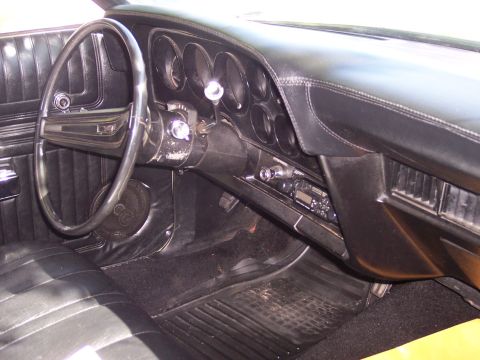 1972 Ford Ranchero - The interior of a car, a black dashboard and seats, with a radio installed.