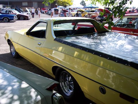 1972 Ford Ranchero - A yellow 1972 Ford Ranchero is parked at an outdoor car show, viewed from the rear three-quarter angle.