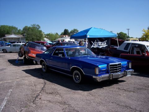 1972 Ford Ranchero - A blue 1977 Ford Ranchero is parked at an outdoor event, with a lifted orange vehicle and other cars visible.