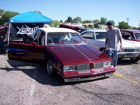 1972 Ford Ranchero - A custom coupe with its doors open sits parked at an outdoor event, with other vehicles nearby.
