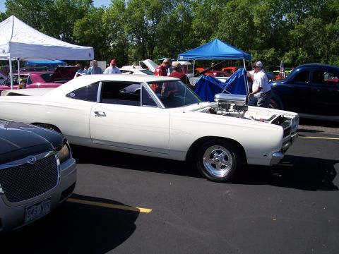 1972 Ford Ranchero - A white 1969 muscle car with its hood open, revealing a large engine, parked at an outdoor event.