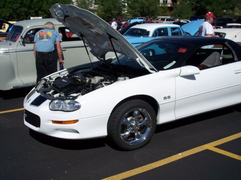 1972 Ford Ranchero - A white Chevrolet Camaro SS is displayed with its hood open at an outdoor car show.
