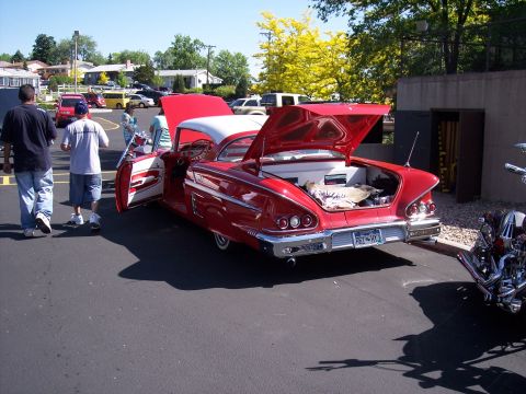 1972 Ford Ranchero - A classic red and white car from 1958 is displayed with its hood and trunk open, revealing its interior and cargo space.