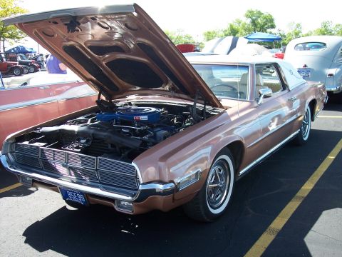 1972 Ford Ranchero - A classic Ford Thunderbird is displayed with its hood up at an outdoor event.