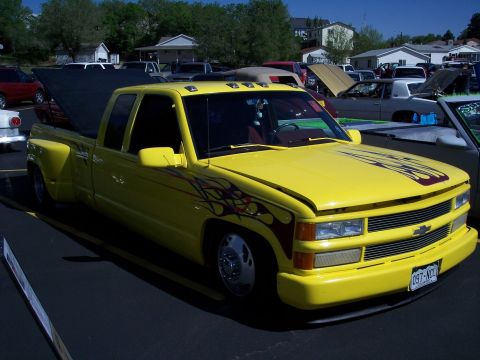 1972 Ford Ranchero - This yellow dually pickup truck features flame graphics on the hood and sides, with a custom front bumper and aftermarket wheels.