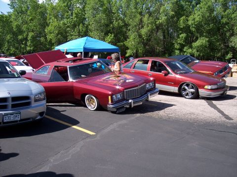 1972 Ford Ranchero - A customized maroon coupe with a mural on the hood and whitewall tires is parked at an outdoor event.