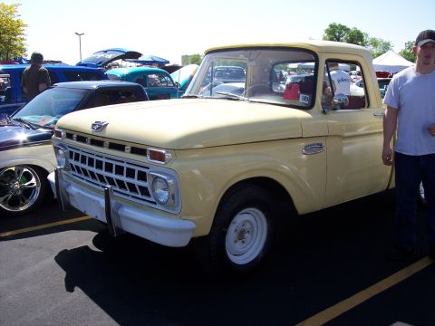 1972 Ford Ranchero - Cream 1965 Ford F-100 pickup truck at an outdoor car show.