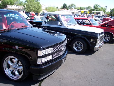 1972 Ford Ranchero - Several vehicles are parked in a lot on a sunny day, with people milling around.