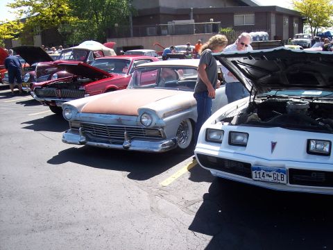1972 Ford Ranchero - Several classic cars are lined up at an outdoor event, with people admiring them.