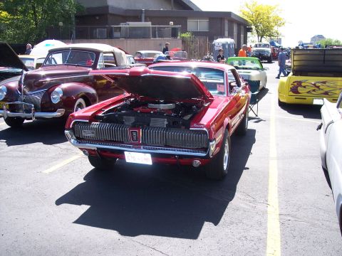 1972 Ford Ranchero - A red 1968 Mercury Cougar XR7 is displayed with its hood open at an outdoor car show.