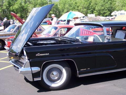 1972 Ford Ranchero - A classic black Lincoln Continental Mark IV is displayed with its hood up at a car show.