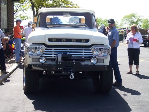 1972 Ford Ranchero - A man and woman stand near a vintage Ford truck at an outdoor event.