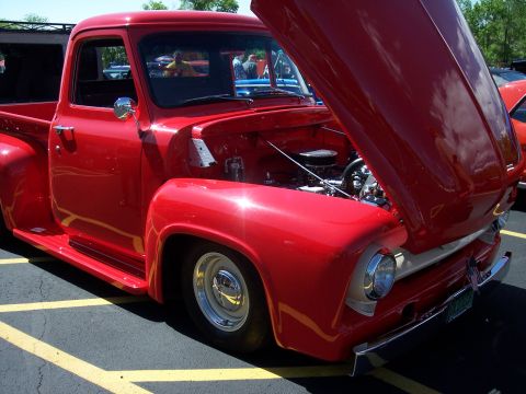 1972 Ford Ranchero - A classic red Ford pickup truck is on display with its hood raised, revealing the engine compartment.