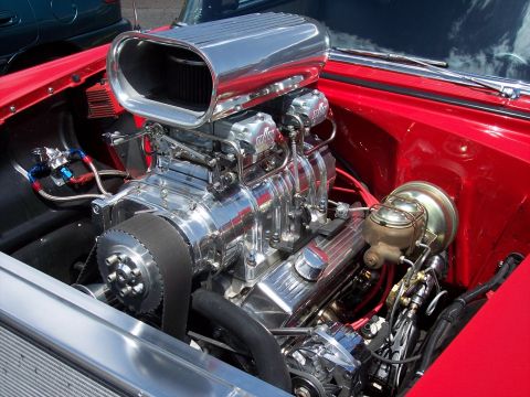 1972 Ford Ranchero - A highly polished engine a prominent supercharger is visible in a red vehicle.
