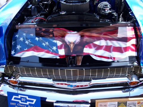 1972 Ford Ranchero - The hood of a blue car features an airbrushed eagle and American flag design, with a '57 Chevy badge below the grille.