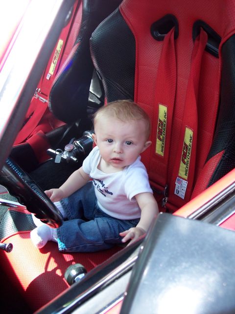 1972 Ford Ranchero - A baby is seated in a car's interior, ready to take the wheel.