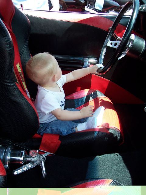 1972 Ford Ranchero - A baby is seated in a car's interior, reaching for the steering wheel.