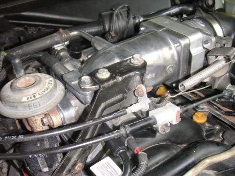 1996 Ford Crown Victoria - Close-up view of engine parts, including hoses and cables, with a silver throttle body visible.