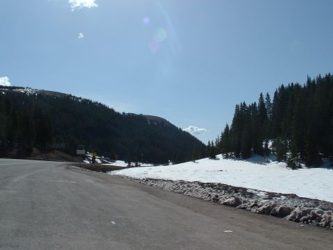 2007 Kawasaki Ninja - A scenic mountain road passes through an area with lingering snow and dense pine forests.
