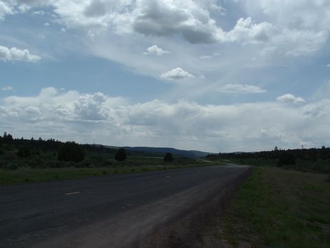 2007 Kawasaki Ninja - A long, empty road stretches into the distance under a dramatic sky filled with clouds.
