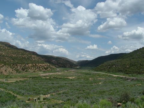 2007 Kawasaki Ninja - A scenic view of a mountain valley under a partly cloudy sky, with a road leading into the distance.